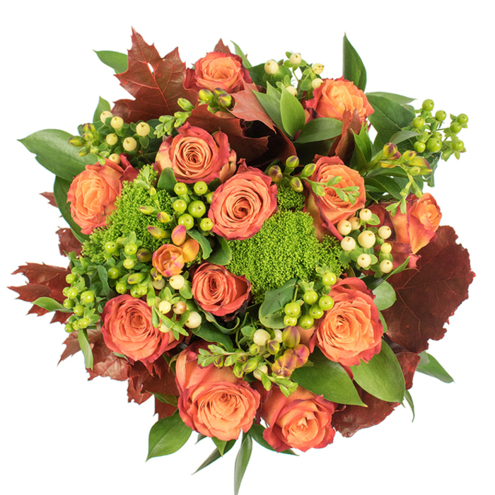 From a bird's-eye view this autumnal arrangement is a lesson in balance and seasonal storytelling. The central chorus of roses displays a pleasing bicolour transition-warm peach at the heart moving outward to coral-orange and finally to russet-tinted petal edges-each bloom opened fully to reveal layered, velvety spirals. Interspersed among these classic blooms are clusters of waxy Hypericum berries in contrasting tones: a punchy lime-green alongside soft cream and pale yellow, which catch the eye and add small, gleaming focal points. Textural contrast comes from vivid Green Trick dianthus, its dense, moss-like appearance providing both colour and an unexpected tactile note that reads almost like miniature green cushions. Filling and framing the design, broad glossy foliage offers a deep verdant backdrop, while larger lobed leaves in burnt orange to deep maroon recall fallen oak or maple, reinforcing the harvest mood. The piece lies against a crisp white surface that allows colours to glow; soft, diffused light defines petal edges and berry highlights, creating subtle depth without dramatic shadow. There is an olfactory suggestion of gentle rose perfume mingling with the fresher, slightly earthy note of the dianthus and greenery. The composition feels luxurious yet grounded-ideal as a Thanksgiving centrepiece, a comforting seasonal gift, or a focal accent in a home near Deptford Market Yard or along Creekside at Convoys Wharf. Prepared with mindful craftsmanship, this bouquet brings the warmth of late-summer light and the comfort of autumnal textures into any room.