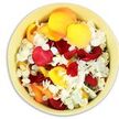 In this image, the camera looks straight down into a round, light butter-yellow ceramic bowl that is completely filled with a lush layer of petals, creating a simple yet powerful tribute. The bowl's smooth, rounded rim forms a gentle boundary for the mingling colours within. Inside, rose petals in rich crimson, glowing yellow, and soft peach-apricot appear to have been scattered by hand and allowed to fall where they may, forming natural folds and hollows that catch small pockets of light and shadow. Their surfaces look thick and velvety, suggesting a softness that would yield easily to touch, much like the tender emotions surrounding a farewell.
Among these larger rose petals are sprinkled numerous tiny white hydrangea florets. Each little cluster offers a frothy, ruffled texture, resting lightly across the heavier petals as though placed with care. The white of the hydrangea brings balance and serenity, tempering the stronger tones so the arrangement feels contemplative rather than bright or celebratory. The lighting is clear and even, much like soft daylight falling into a room off Deptford Church Street, allowing the viewer to discern every contour, overlap, and subtle variation in hue. This bowl of petals could be imagined beside a framed photograph at a memorial service, at the front of a chapel, or on a side table in a Deptford home where family and friends gather to remember. The petals suggest a final act of tenderness-something to scatter at a graveside, to keep as a memento, or simply to gaze upon while recalling shared moments, offering visual comfort in a time of loss.